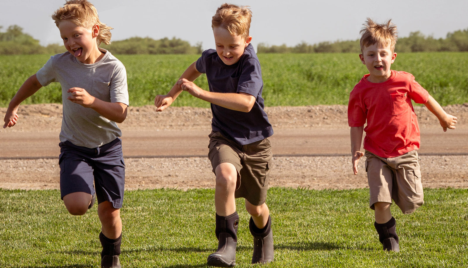 3 wild boys running in the grass