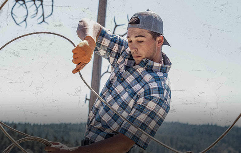 man in short sleeve shirt wearing roping gloves, doing roping tricks